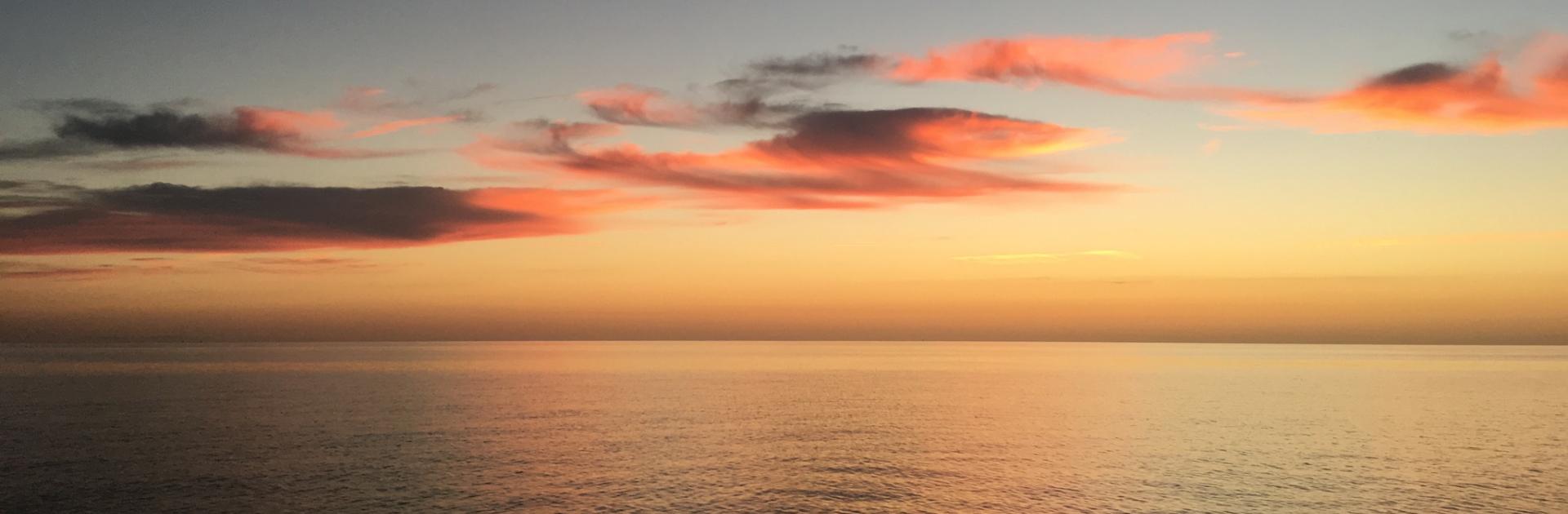 A setting sun on the Chesapeake Bay dyes the clouds pink. 