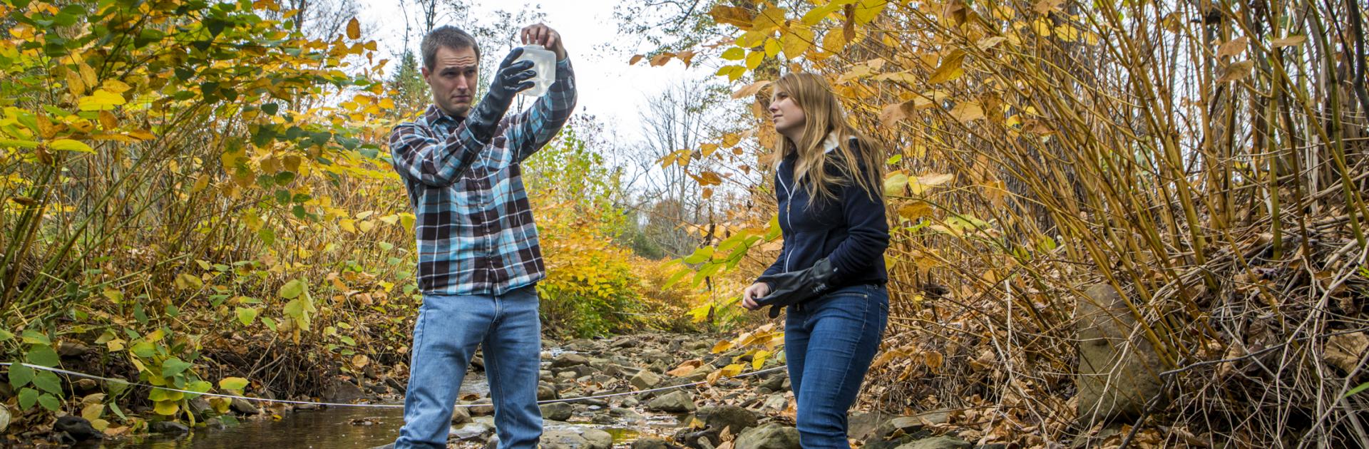 two people testing water in a stream