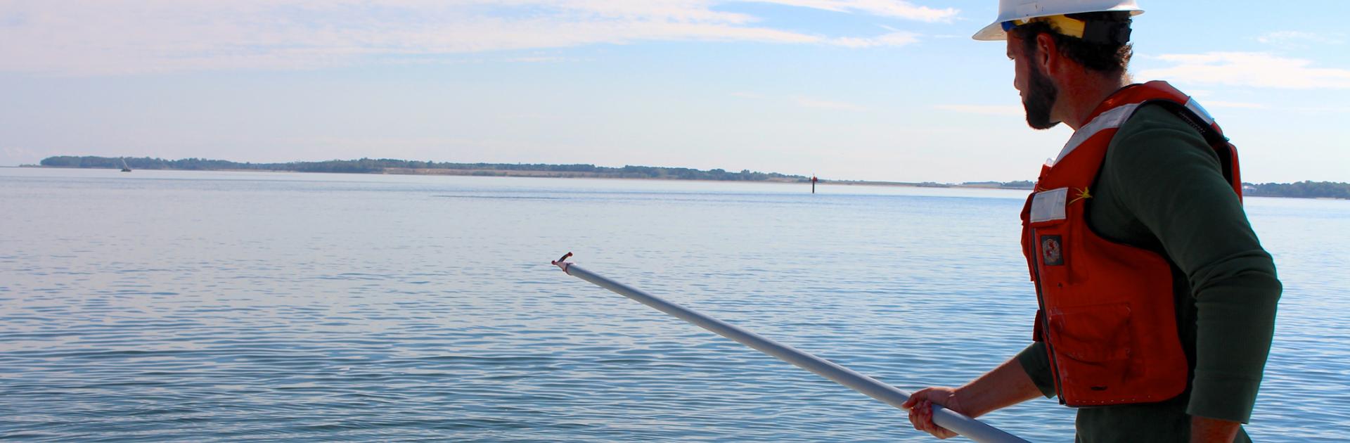 person standing in the water with a pole