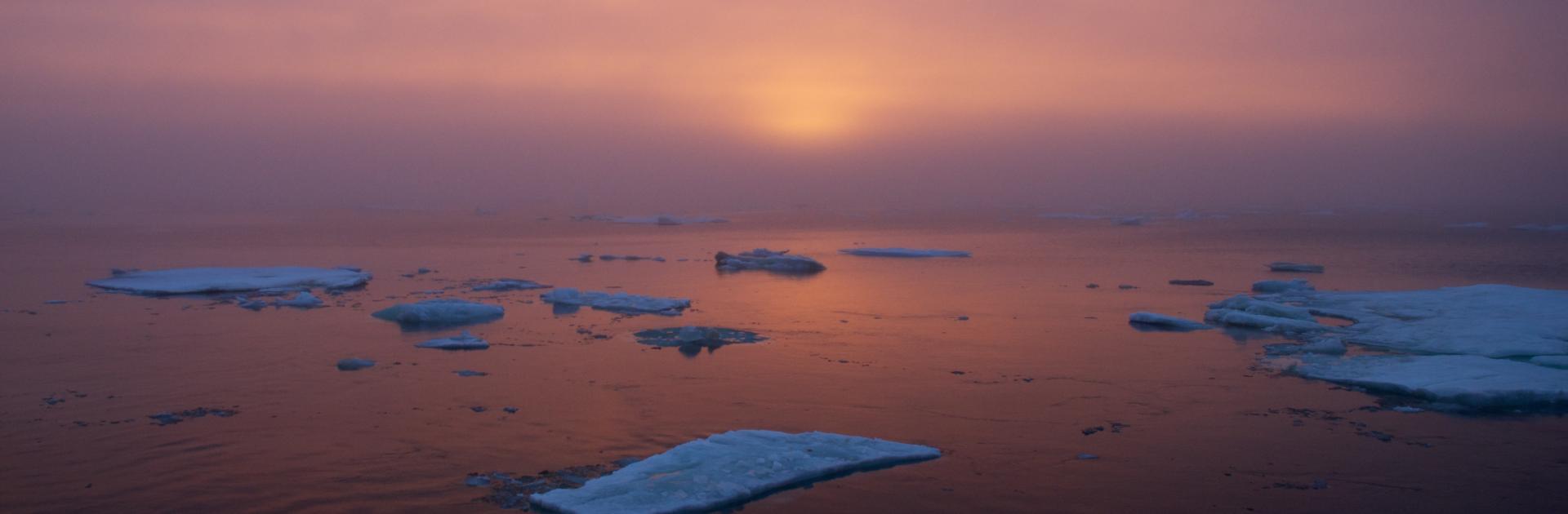 The sun sets over ice-dotted Arctic waters. Photo by Johnny Sullivan, US Coast Guard