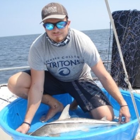 Chris smiling, while displaying a fish