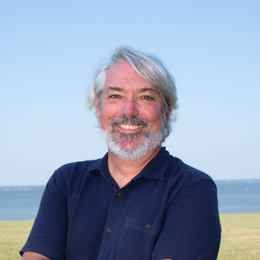 Photo of James Pierson with a field and the Choptank River in the distance.