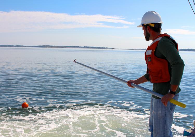 person standing in the water with a pole