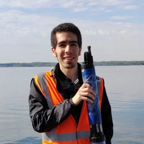 Amir Reza Azarnivand participating in research near a still body of water