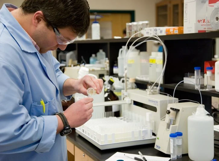 Water Chemistry Laboratory technician pouring samples into tubes for analysis.