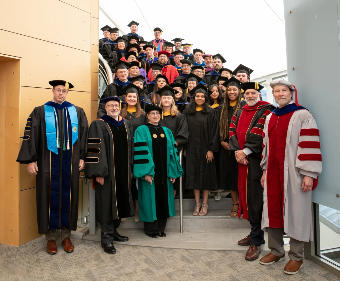 Group shot of graduates and faculty at commencement 2024