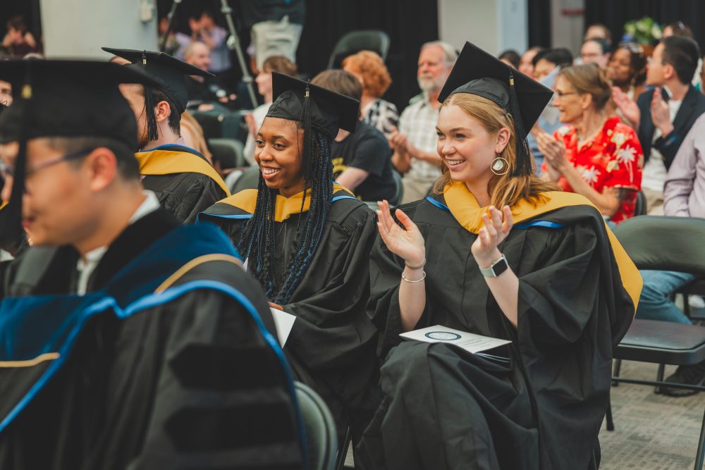 UMCES graduates applauding a speaker at commencement.