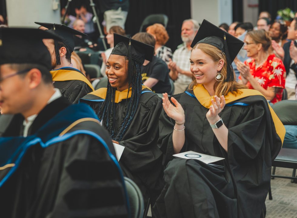 UMCES graduates applauding a speaker at commencement.