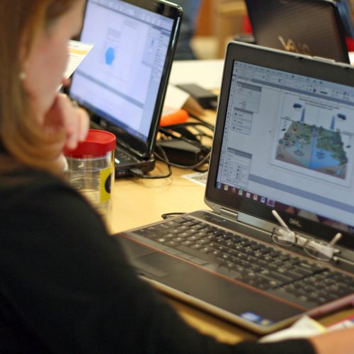 Person working on a laptop computer to create science communication documents