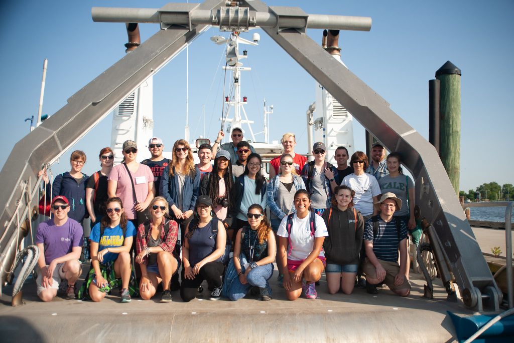 A group of people pose together on the research vessel Rachel Carson