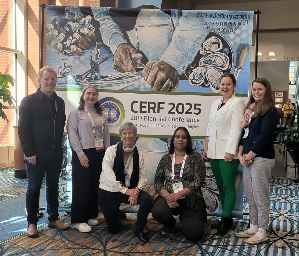 Maryland Sea Grant staff and fellows in front of a CERF 2025 conference sign