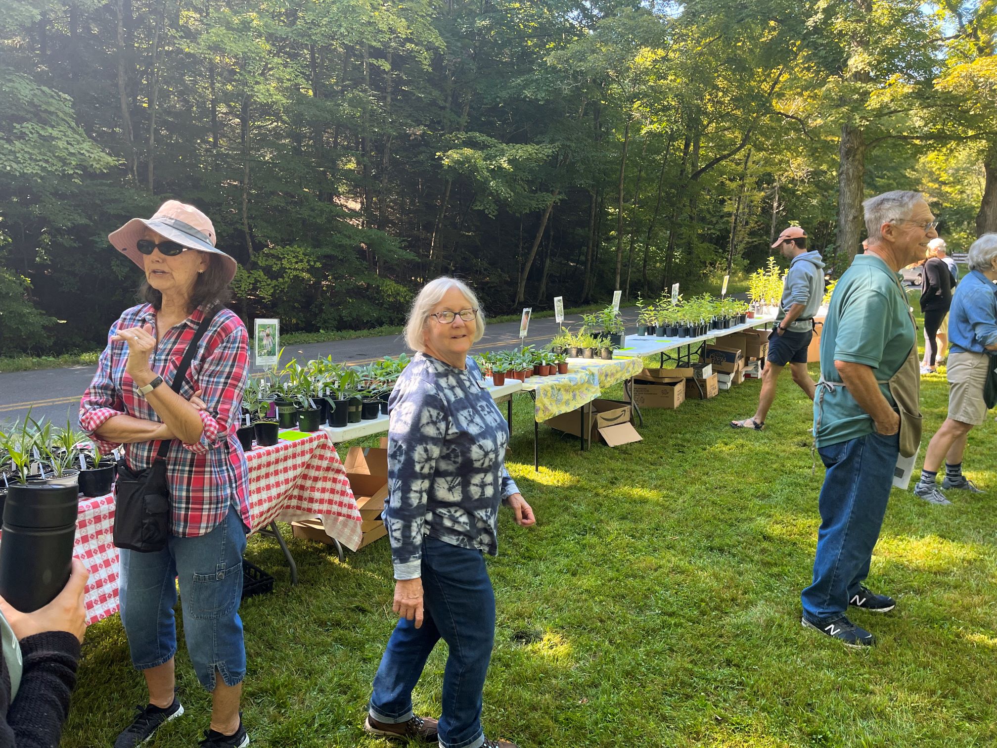 Garden club members interact with members of public during annual plant sale.