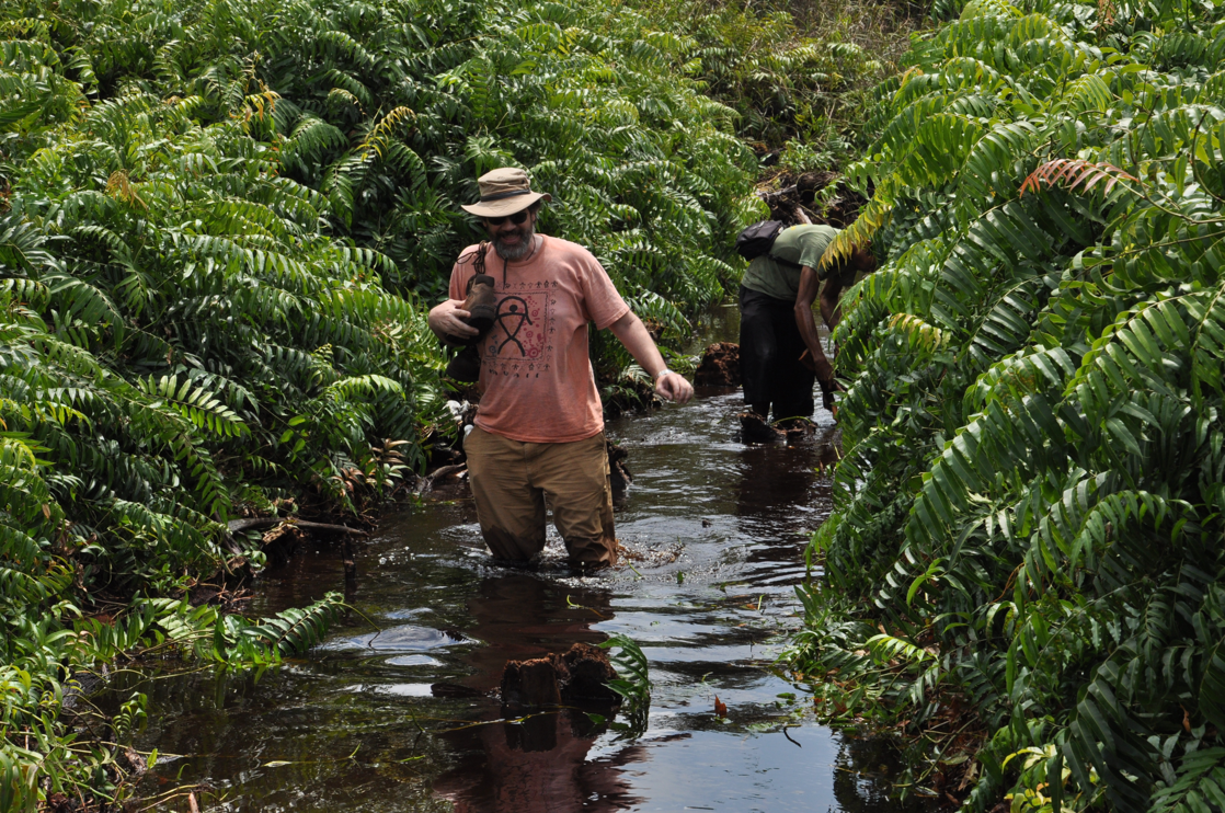 Mark Cochrane hikes through water in Indonesia.