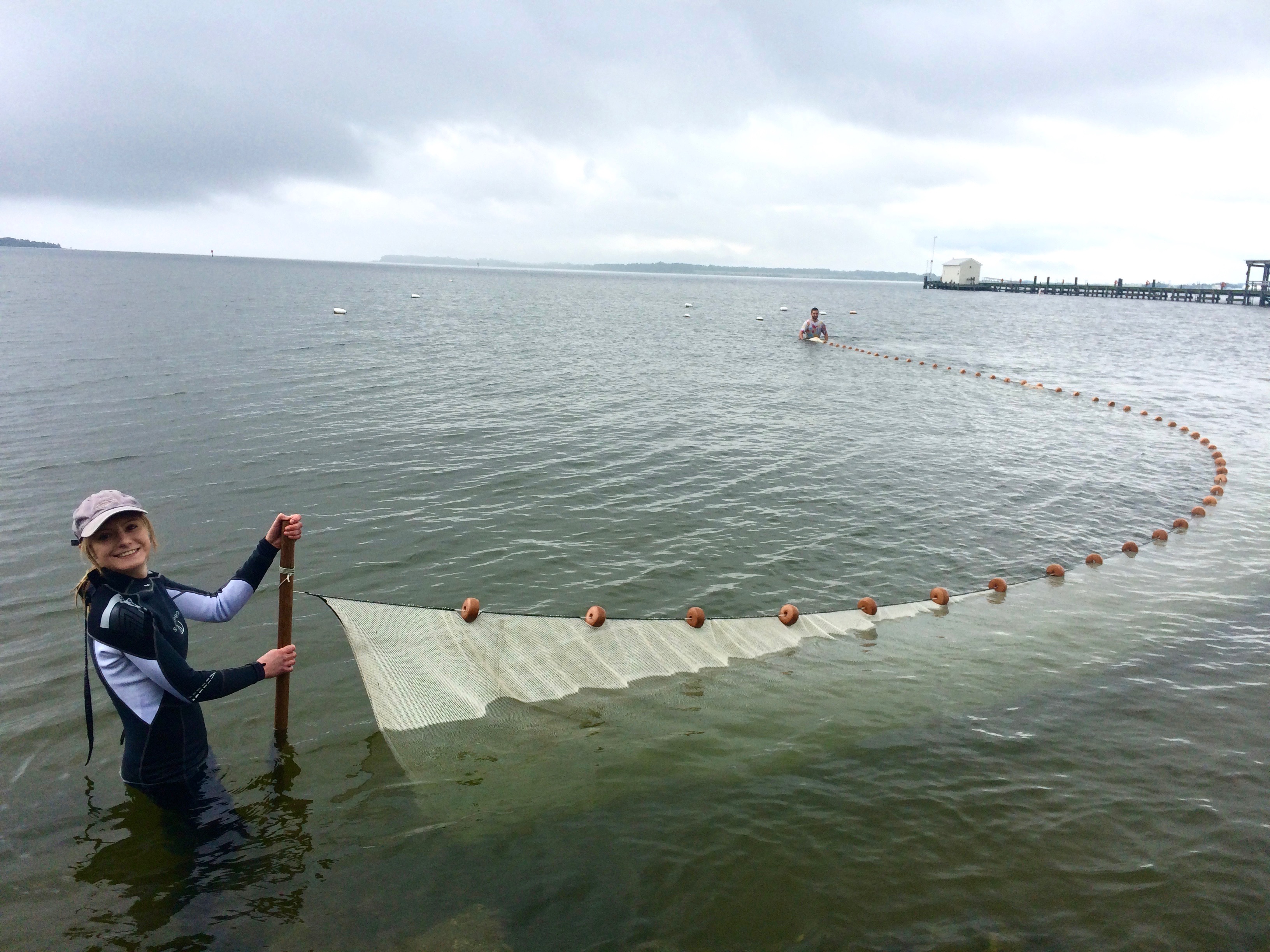 Ellie in the ocean holding a net to catch fish