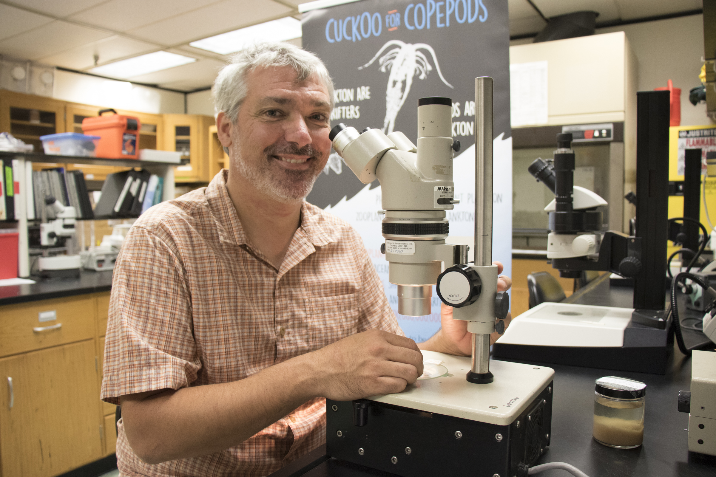 Jamie Pierson in his laboratory with a microscope